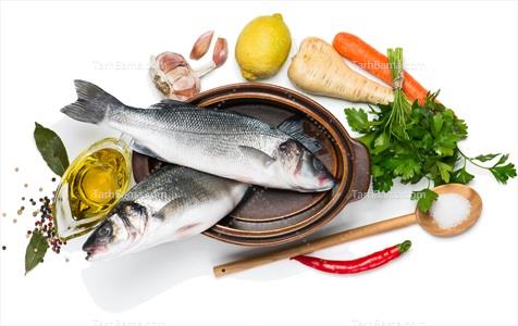 تصویر با کیفیت ماهی قزل آلا در قابلمه کنار وسایل آشپزی